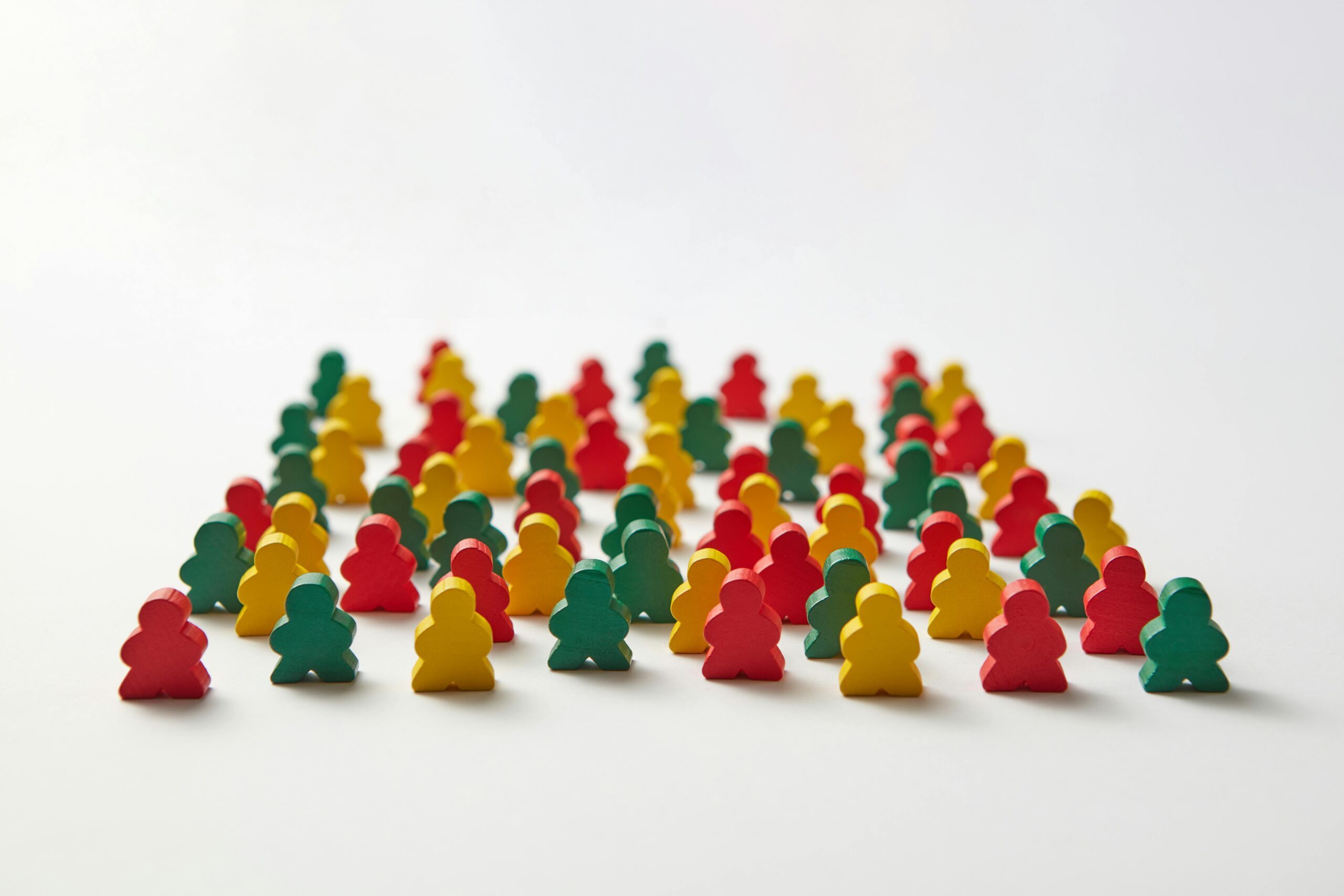 A collection of colorful wooden figures arranged on a white background in a grid-like pattern.